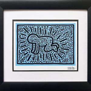 May include: A black and white abstract print of a dog on a light blue background. The print is framed and includes the text "Keith Haring COLLECTION".