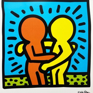 Puede incluir: Una impresi&oacute;n colorida de dos figuras abraz&aacute;ndose, una en naranja y la otra en amarillo, con contornos negros. Las figuras est&aacute;n sobre un fondo azul con rayos de sol negros. La impresi&oacute;n est&aacute; firmada "Keith Haring Collection".