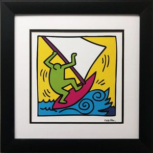 May include: A colorful print of a green figure on a red surfboard riding a wave with a yellow background and a white sail. The artist's signature "Keith Haring" is in the bottom right corner.