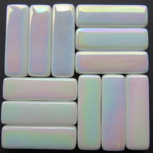 May include: Arrangement of rectangular, iridescent tiles with rounded edges. The tiles have a pearlescent sheen, reflecting a spectrum of colors including white, pink, and green. The tiles are arranged in a grid pattern against a dark background.
