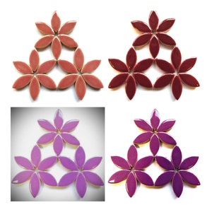 May include: A set of 12 ceramic flower-shaped tiles in three colors: pink, burgundy, and purple. The tiles are arranged in a triangular pattern.