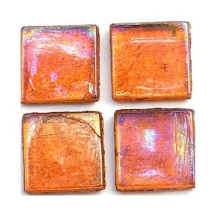 May include: Four square orange glass tiles with iridescent highlights. The tiles have a textured surface and a warm, inviting color palette. These tiles are suitable for mosaic projects or decorative applications.