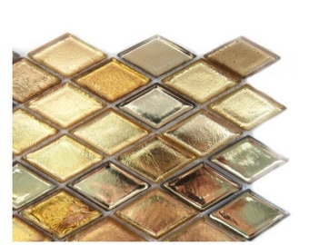 May include: Close-up of a section of diamond-shaped mosaic tiles. The tiles have a metallic, reflective surface with shades of gold, bronze, and silver. The mosaic is arranged in a grid pattern, creating a textured and decorative surface.