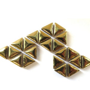May include: A collection of gold-colored triangular mosaic tiles arranged in a geometric pattern.
