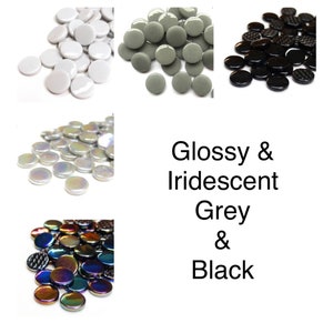 May include: Assortment of glossy and iridescent glass tiles in grey and black. The tiles are round and have a smooth, polished finish.