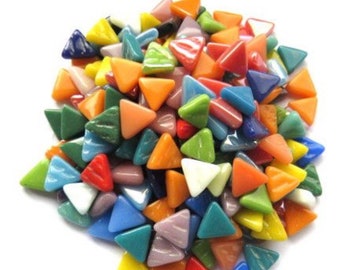 May include: A pile of colorful, triangular glass mosaic tiles in various shades of blue, green, orange, red, yellow, and white. The tiles are smooth and glossy, perfect for crafting and decorative projects.
