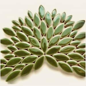 May include: A green leaf-shaped ceramic mosaic tile sheet. The tiles are arranged in a fan shape, creating a decorative pattern.