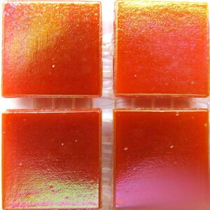 May include: Four square iridescent glass tiles in a vibrant orange color. The tiles have a subtle shimmer and a textured surface.
