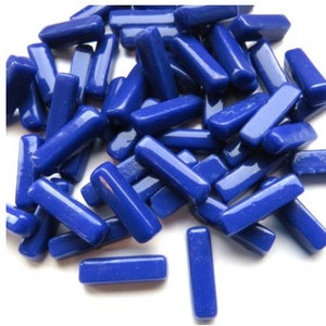 May include: A pile of cobalt blue glass tiles in a rectangular shape. The tiles are smooth and glossy.
