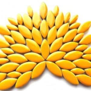 May include: A collection of yellow ceramic tiles in the shape of elongated leaves, arranged in a fan-like pattern.