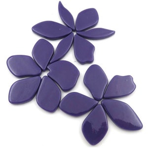 Pu&ograve; includere: Un set di piastrelle a mosaico di fiori in vetro viola. Le piastrelle hanno la forma di petali e sono disposte a forma di fiore.