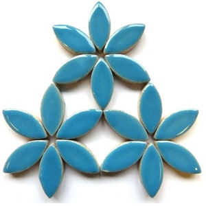 Op de afbeelding: Een set van 12 blauwe keramische tegels in de vorm van een bloem. De tegels zijn in een bloemmotief gerangschikt.