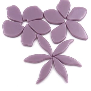 Pu&ograve; includere: Un set di piastrelle a mosaico di fiori di vetro viola. Le piastrelle hanno la forma di petali e foglie.