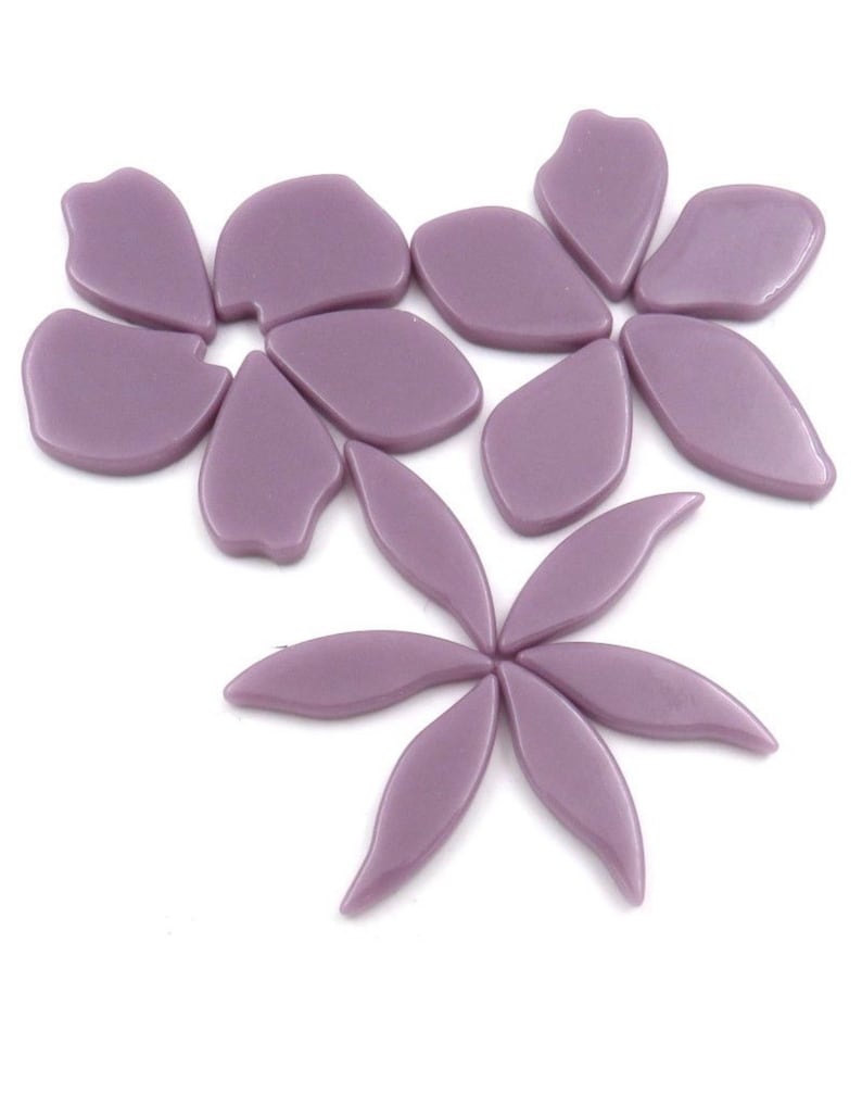 Pu&ograve; includere: Un set di piastrelle a mosaico di fiori di vetro viola. Le piastrelle hanno la forma di petali e foglie.