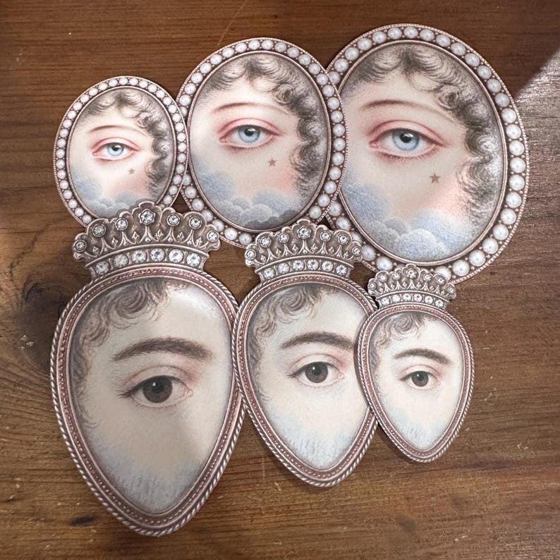 May include: A collection of antique-style oval and heart-shaped portraits. The portraits feature detailed illustrations of eyes and faces, some with crowns. The color palette includes soft pinks, blues, and browns, with a pearl-like border.