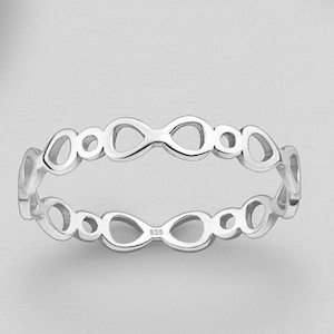 May include: A silver ring with a delicate, openwork design featuring a repeating pattern of circles and ovals. The ring is marked with "925", indicating it is made of sterling silver.