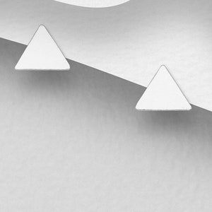 May include: A pair of silver triangle stud earrings. The earrings are small and simple, and they would be a great addition to any jewellery collection.