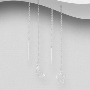 May include: Four silver dangle earrings with a crescent moon, a star, and two straight lines as charms.