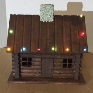 Miniature Wood Cabin With 18 Multi Colored Xmas Lights, 3 Settings, Steady On, Flashing, Fading, 6hrs On 18hrs Off Timer.