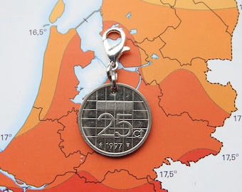 May include: A silver-coloured circular charm featuring a 25 cent coin design with a grid pattern, the number 25, the abbreviation ct, and the year 1997. The charm is attached to a silver-toned lobster claw clasp for easy attachment to jewellery.