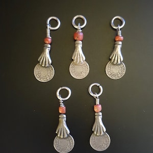 Morocco – 5 Antique silver coins pendants held by a hand and genuine coral bead