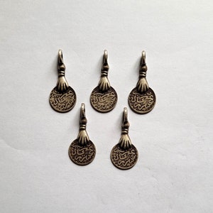 Morocco – 5 Antique silver coins pendants held by a hand
