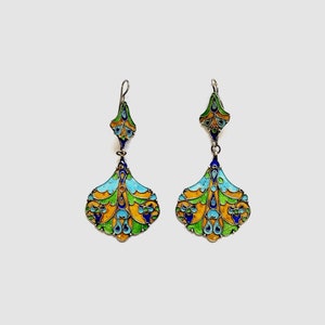 Puede incluir: Un par de pendientes colgantes con un diseño de esmalte azul, verde y amarillo. Los pendientes están hechos de plata y tienen un diseño delicado e intrincado.