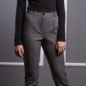 May include: Black and white houndstooth patterned pants with a high waist and a slim fit.