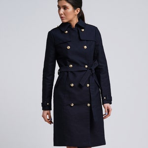 May include: A navy blue double-breasted trench coat with gold buttons and a belt.