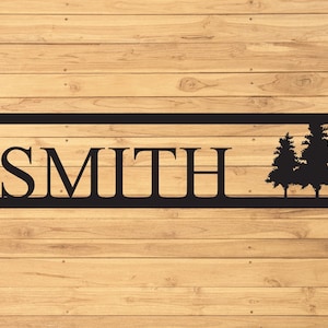 May include: Black metal sign with the last name "SMITH" in large block letters and two stylized pine trees on the right side.