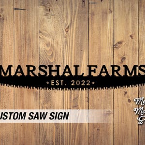 May include: Black metal saw sign with the text "MARSHAL FARMS EST. 2022" on a wood background.