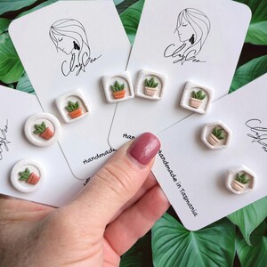 May include: A set of handmade polymer clay earrings featuring potted plants in various shapes and sizes. The earrings are displayed on white cards with the text "Clay Crea" and "handmade in Tasmania".