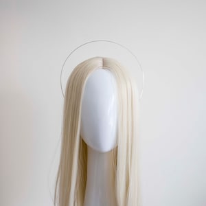 May include: A silver halo headband, a circular wire accessory for the head.