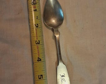 Colher de prata de lei com marca de contraste representando um braço com um martelo, 16 g, monograma FC.