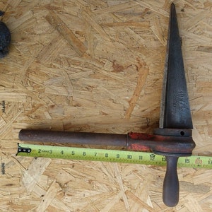 May include: A rusty metal pipe cutter with a red handle and a long, pointed blade. The cutter is 18 inches long.