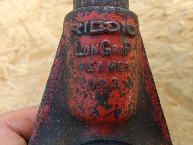 May include: A red and black pipe wrench with the text "RIDGID LONG GRIP MADE IN AMERICA NO. 3" on the side.