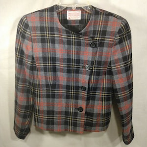 May include: A gray, black, red, and yellow plaid blazer with a single button closure on the front. The blazer has a slightly asymmetrical design and is made of a soft, woven fabric.