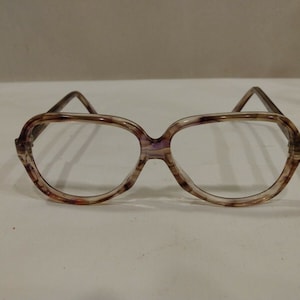 May include: A pair of brown and white tortoiseshell eyeglasses with clear lenses.