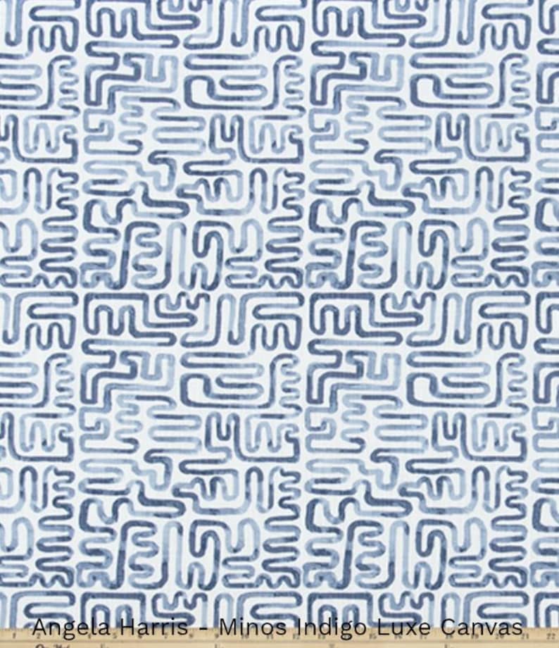May include: White canvas fabric with a repeating pattern of blue, maze-like shapes. The fabric is labeled "Angela Harris - Minos Indigo Luxe Canvas". The design features varying shades of blue, creating a textured appearance.