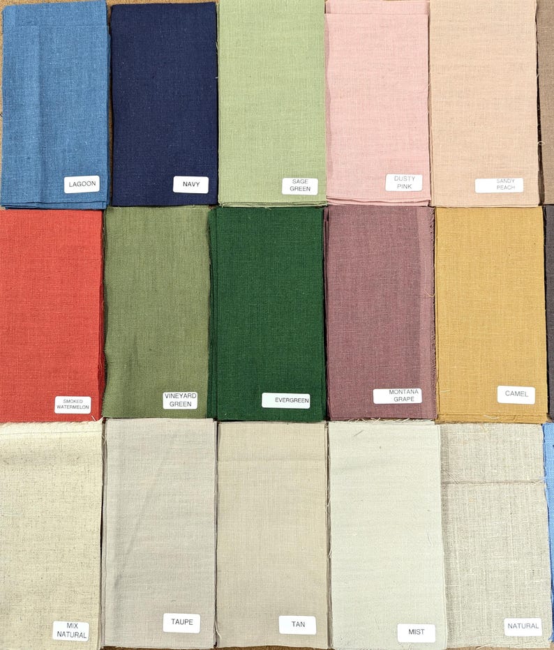 K&ouml;nnte beinhalten: Eine Sammlung von Stoffmustern in verschiedenen Farben, darunter Blau, Gr&uuml;n, Rosa und Beige. Jedes Muster hat ein Etikett mit einem Farbnamen, wie "Lagoon", "Navy" und "Evergreen". Die Stoffe scheinen aus Leinen oder einer &auml;hnlichen Naturfaser zu bestehen.