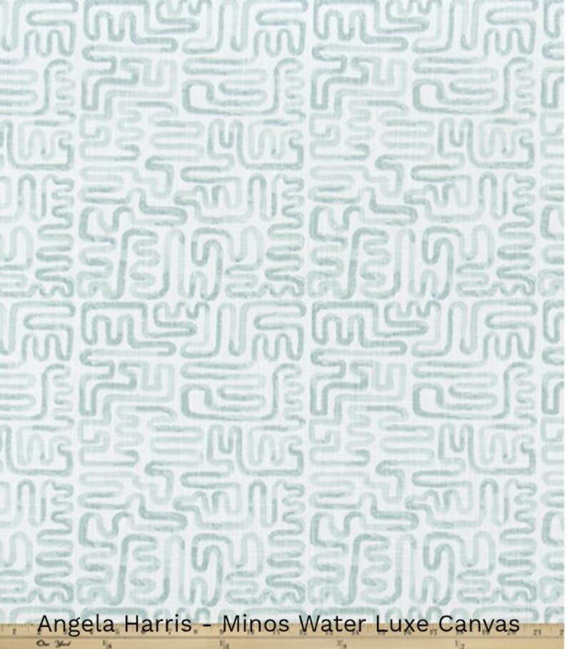 May include: A fabric with a repeating pattern of abstract, light blue lines on a white background. The lines form a maze-like design. The text "Angela Harris - Minos Water Luxe Canvas" is printed at the bottom.
