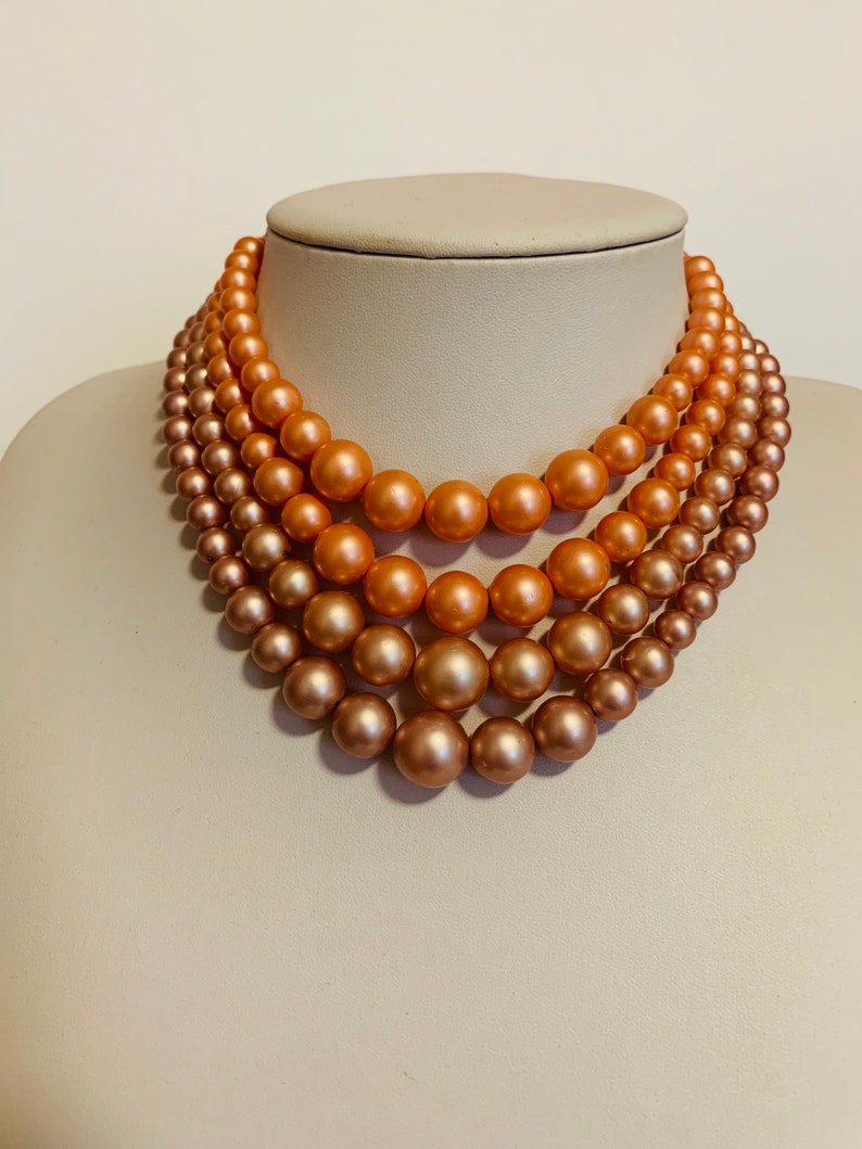Multi strand pink and peach beaded necklace with hook closure.