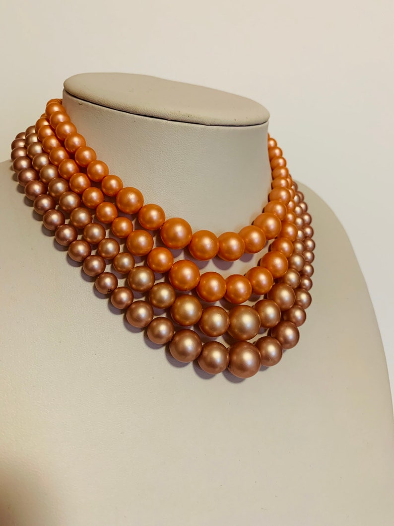 Multi strand pink and peach beaded necklace with hook closure.