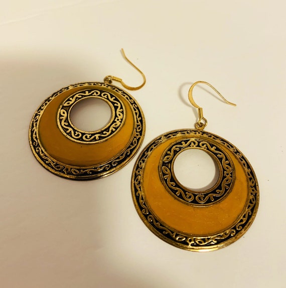 Dangling gold tone metal with scrolled design with