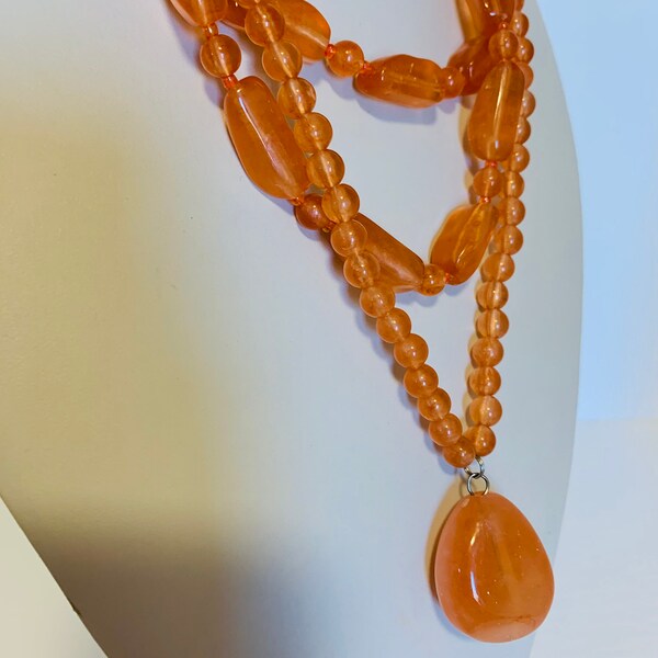 Collar naranja multi hebra con gran colgante de piedra naranja.