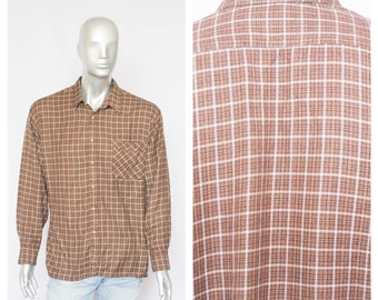 May include: A brown and white plaid long-sleeve shirt with a button-down collar and a single pocket on the left chest.