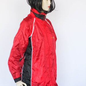 May include: A red and black windbreaker jacket with white piping. The jacket has a zipper closure and a stand-up collar.