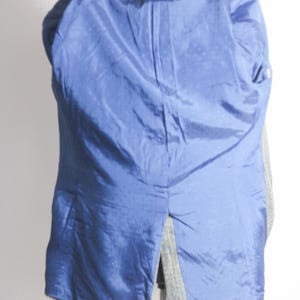 Pu&ograve; includere: Un blazer a spina di pesce grigio e nero con fodera blu. Il blazer &egrave; sbottonato e girato al rovescio, mostrando la fodera.