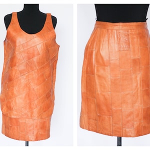 Peut inclure: Une jupe et un haut sans manches en cuir marron, tous deux faits de carrés de cuir en patchwork.