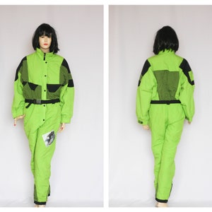 May include: A lime green ski suit with black accents and a geometric pattern. The suit has a zipper closure, a belt, and a patch on the leg.